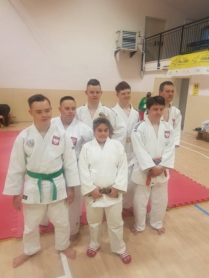 Amanda Orrbo och sex andra judoka i det polska laget står bredvid varandra i vit judodräkt.