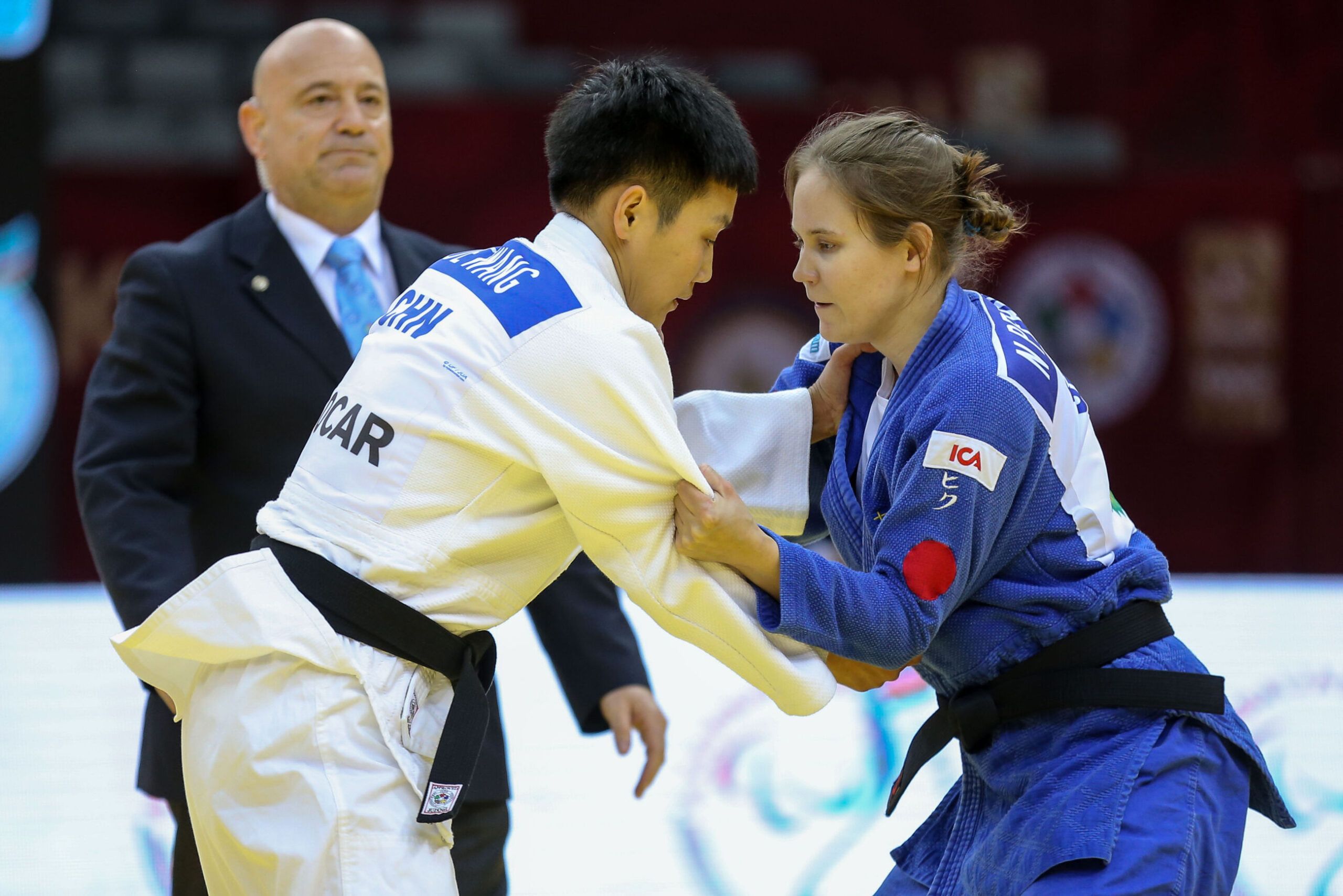 Nicolina Pernheim greppar motståndaren i en match på Grand Prix i Baku 2019. Båda står upp. I bakgrunden syns en domare.
