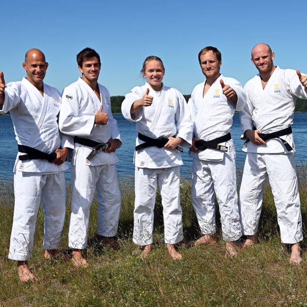 Landslaget står uppställda på rad klädda vit judodräkt.
