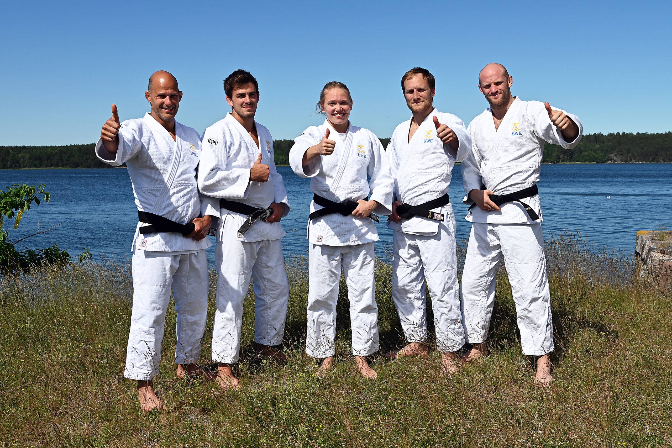 Landslaget står uppställda på rad klädda vit judodräkt.