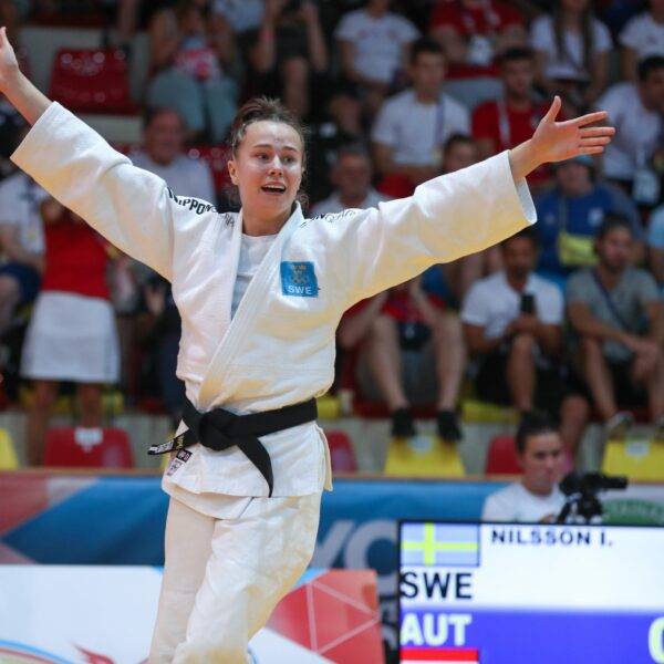 Ingrid Nilsson i vit judodräkt sträcker armarna ut åt sidan i en segergest.
