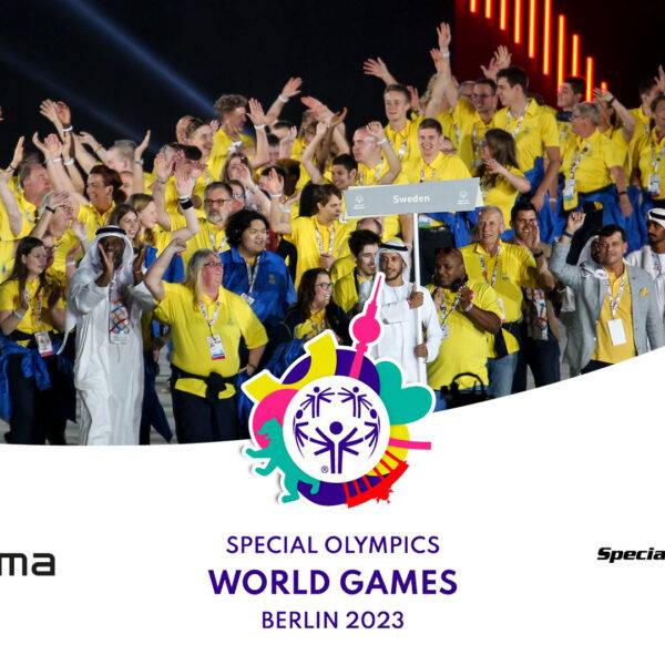 Gruppbild på Sveriges trupp vid ett tidigare Special Olympics. Alla bär gula tröjor.
