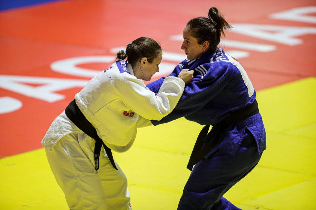 Nicolina Pernheim Goodrich och hennes motståndare står mitt emot varandra på judomattan och greppar varandras judodräkter.