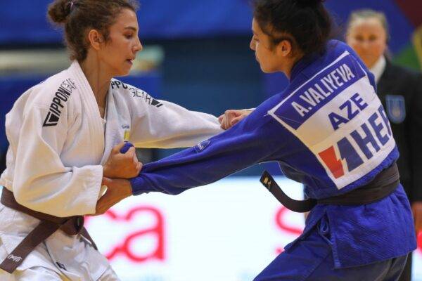 Tara Babulfath i vit judodräkt och brunt bälte greppar sin motståndares judodräkt på tävling.