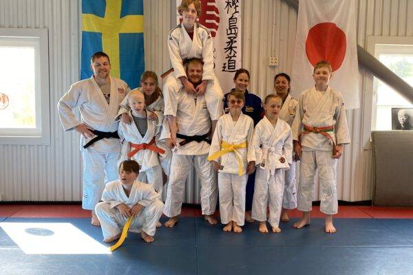 Barn- ungdomar och tränare i judodräkter.