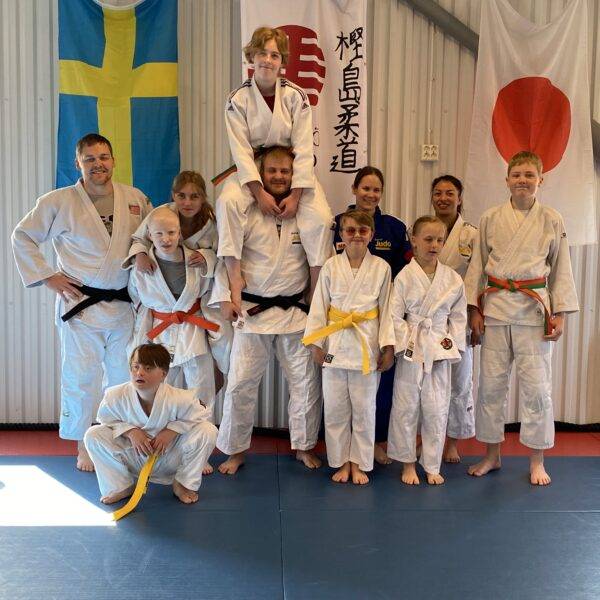 Barn- ungdomar och tränare i judodräkter.