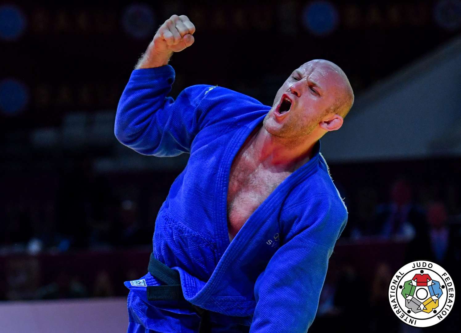 Marcus Nyman i blå judodräkt knyter handen i en segergest.