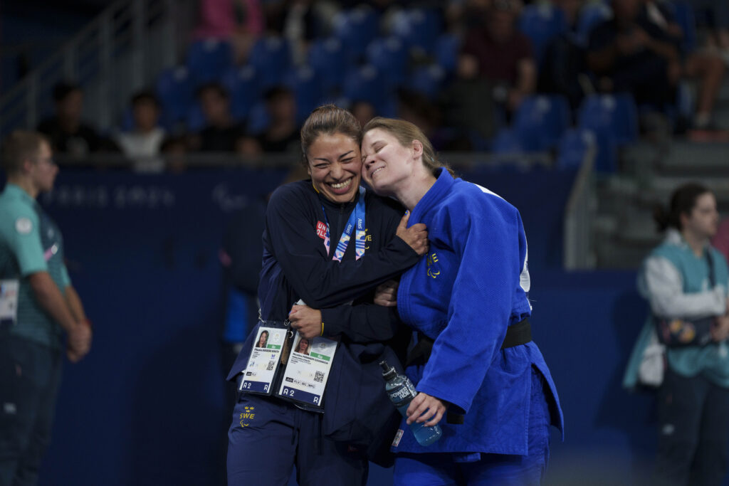 Mikaela Barrera Birath och Nicolina Pernheim Goodrich lutar huvudena motvarandra i sidokram. Båda ler stort.